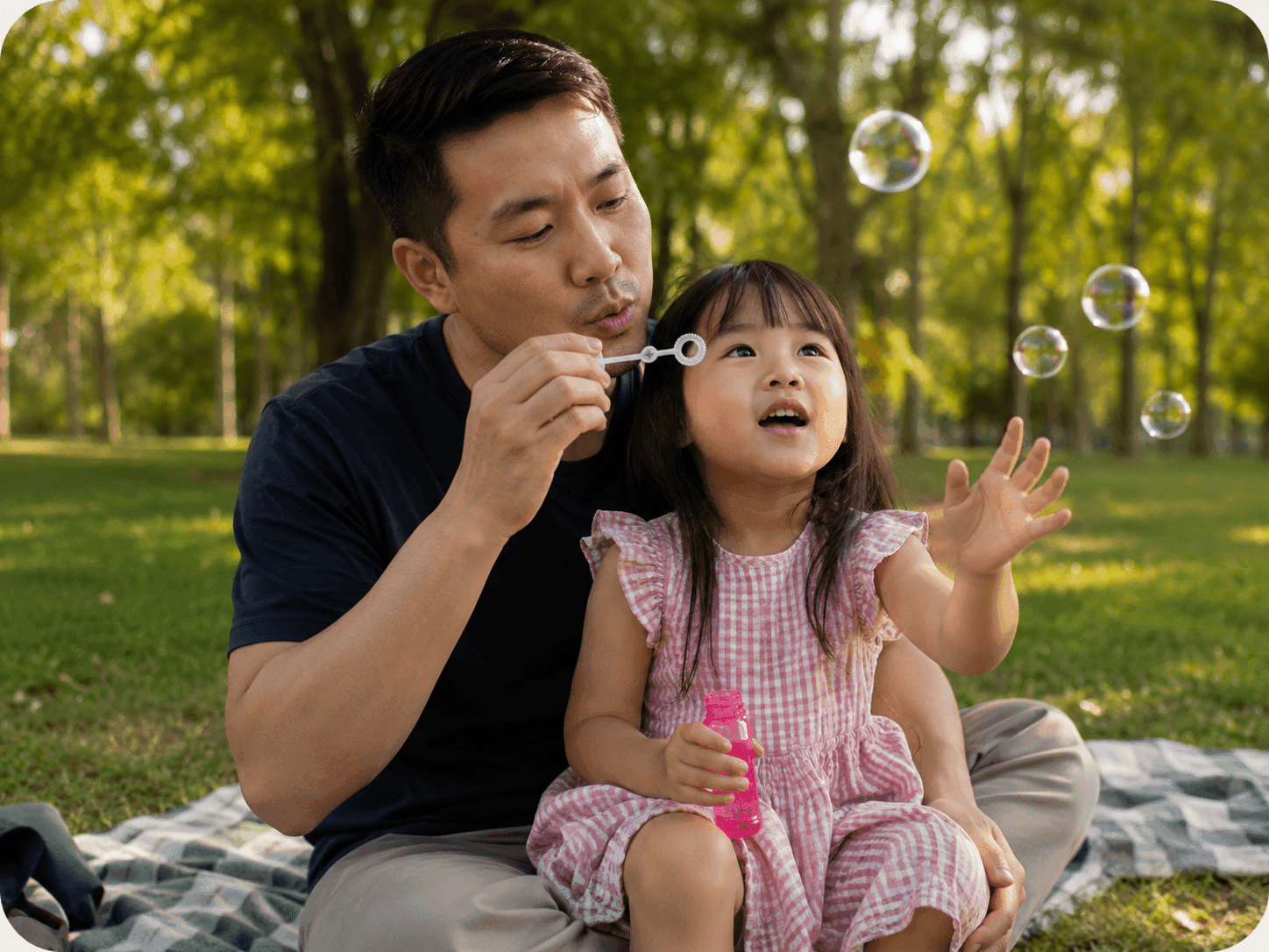 A father and his daughter blowing bubbles and playing together